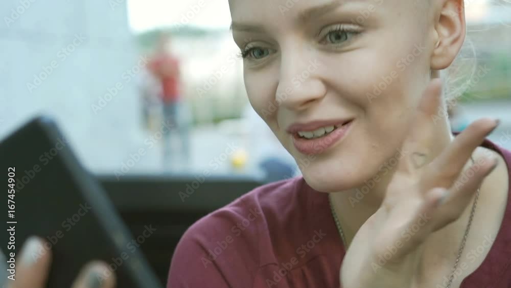 Pretty girl looks happy while having a videocall on smartphone in the outdoor cafe, steadycam shot
Pretty girl looks happy while having a videocall on smartphone in the outdoor cafe, steadycam shot