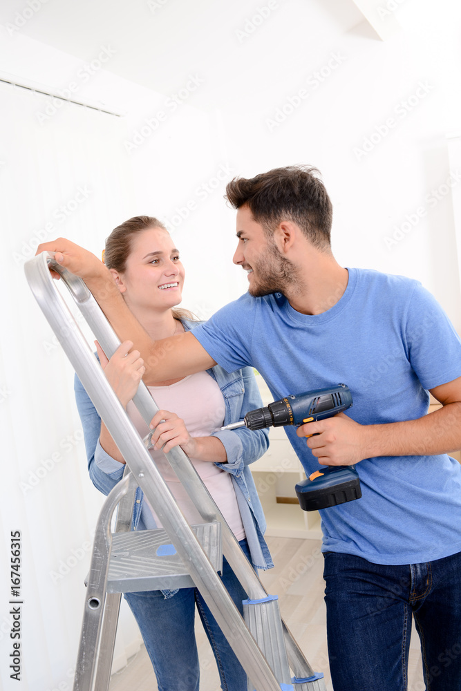 Obraz premium cheerful and happy young couple renovating and painting new home