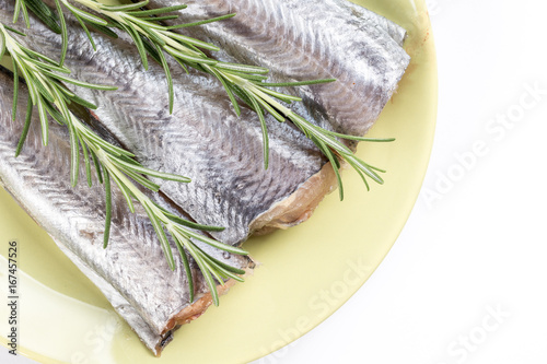 Flat lay above hake fish slices with rosemary branches