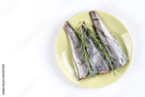 Flat lay copy space above hake fish with rosemary on the plate