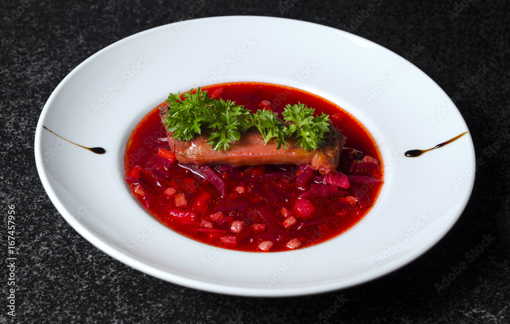 A real Russian borsch on a white plate and black marble with a rib A real Russian borsch on a white plate and black marble with a rib