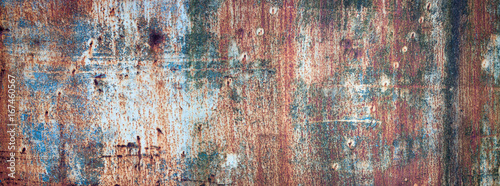 Rusty metal sheet background, rust with peeling multicolored paint