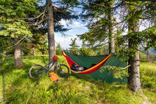 Camping with hammock in summer woods on bike travel