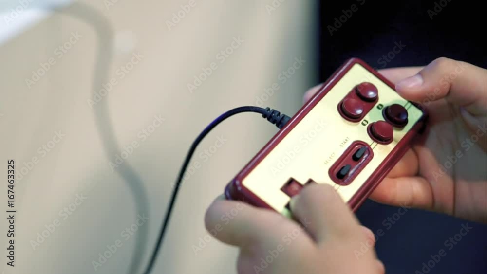 Retro classic gamepad and hands of player. Player pressing buttons and playing in video game. Close up view