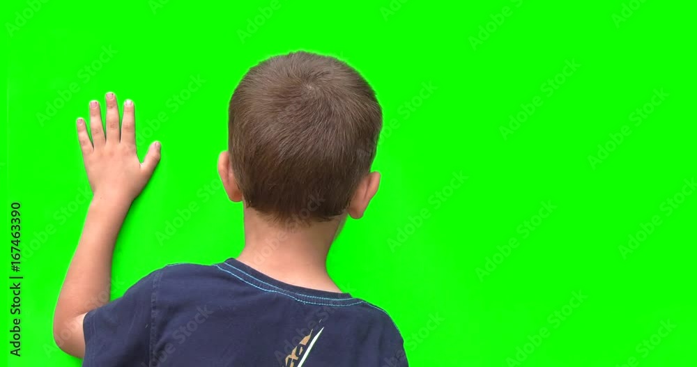 Bambino su sfondo verde chroma key saluta con la mano