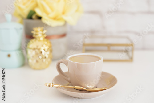 Feminine workplace concept. Freelance fashion comfortable femininity workspace with coffee  flowers  golden pineapple  coffee maker on white background. Pale blue  yellow and gold