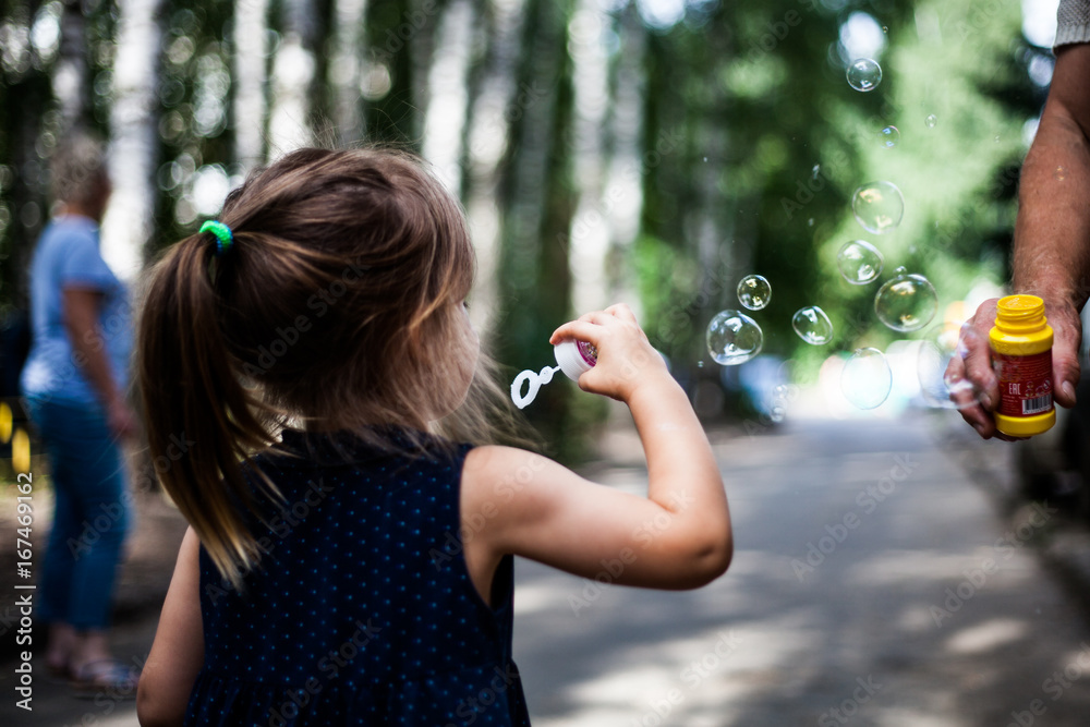 Baby blowing bubbles in a park Baby blowing bubbles in a park