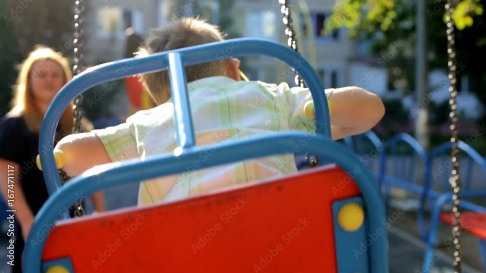 Mom shakes her child on a swing Mom shakes her child on a swing