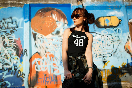 Pretty young woman near graffiti wall