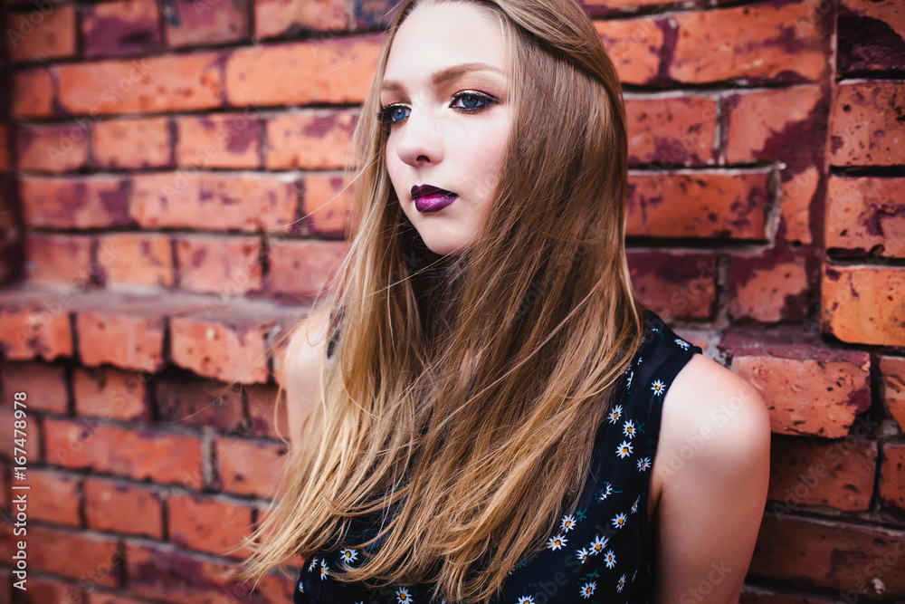 Fototapeta premium Magnificent girl with professional make-up and red lips on the street