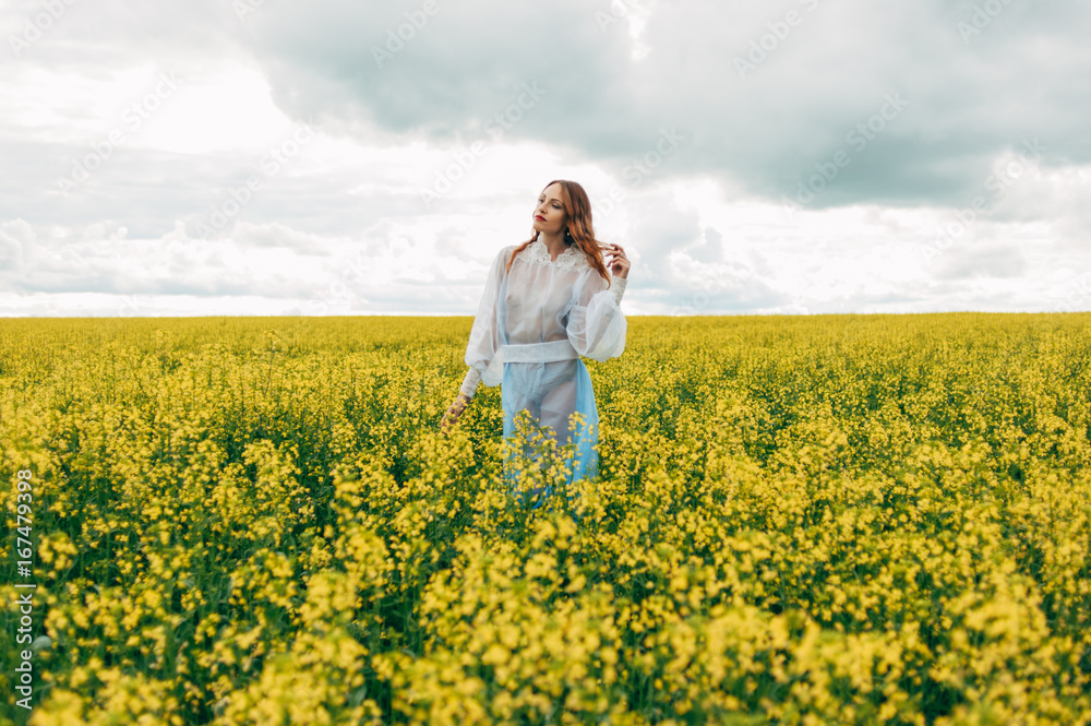 Beautiful girl in a dress among yellow flowers in a field Beautiful girl in a dress among yellow flowers in a field