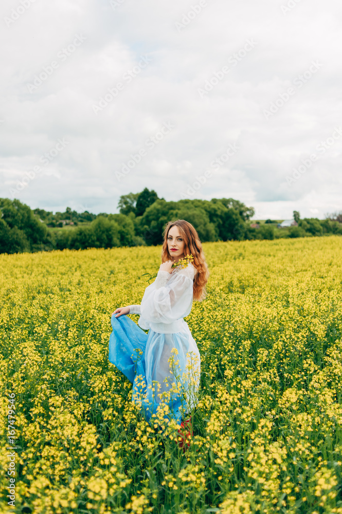 Beautiful girl in a dress among yellow flowers in a field Beautiful girl in a dress among yellow flowers in a field