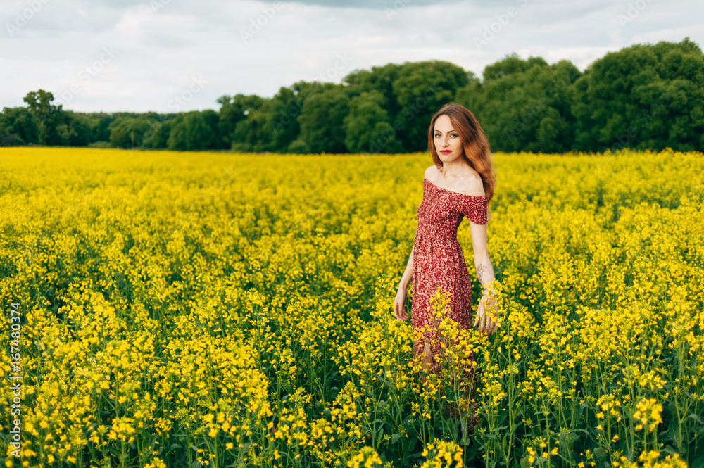 Beautiful girl in a dress among yellow flowers in a field Beautiful girl in a dress among yellow flowers in a field