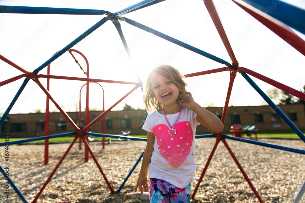 Girl on monkey bars in playground Girl on monkey bars in playground