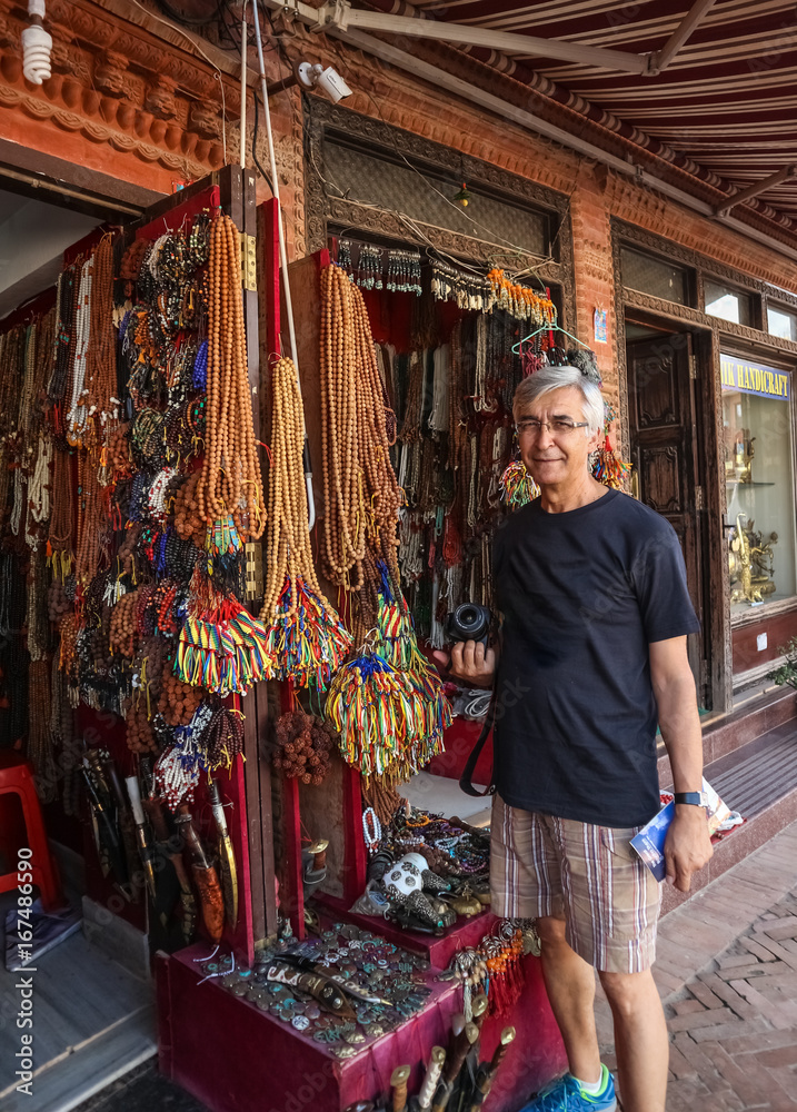 Caucasian tourist man standing in front of a handicraft souvenir shop at Paro, Bhutan