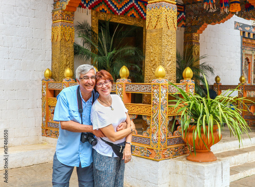 Smiling happy couple standing near the entrance of a temple at Thimphu, Bhutan.