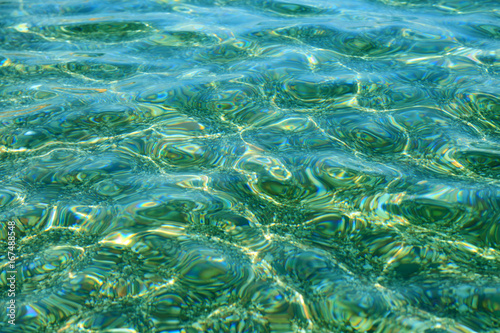 Kolorowe kamienie i fale w przeźroczystej wodzie morza, Śródziemnego.
