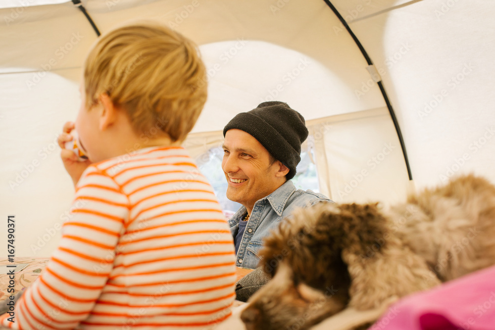 Glamping - Smiling Caucasian Man With Blond Boy Inside Large Circular Tent Glamping - Smiling Caucasian Man With Blond Boy Inside Large Circular Tent