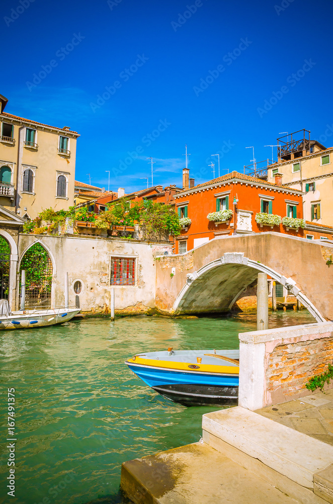 Traditional narrow canal with gondolas in Venice, Italy