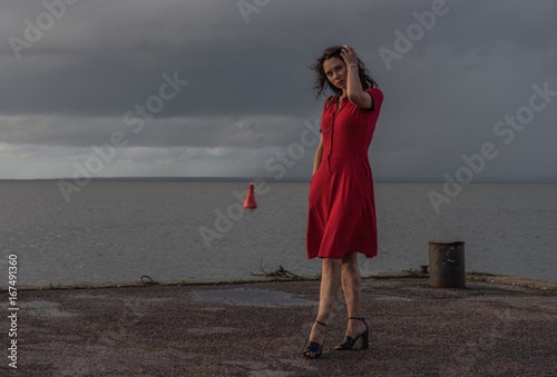 beautiful woman in red dress on the sea