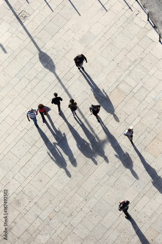 Abstract people and there shadows on city street. Sunny summer day