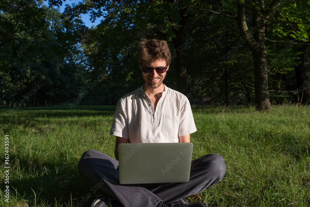 Travailler sur son ordinateur dans un parc Travailler sur son ordinateur dans un parc