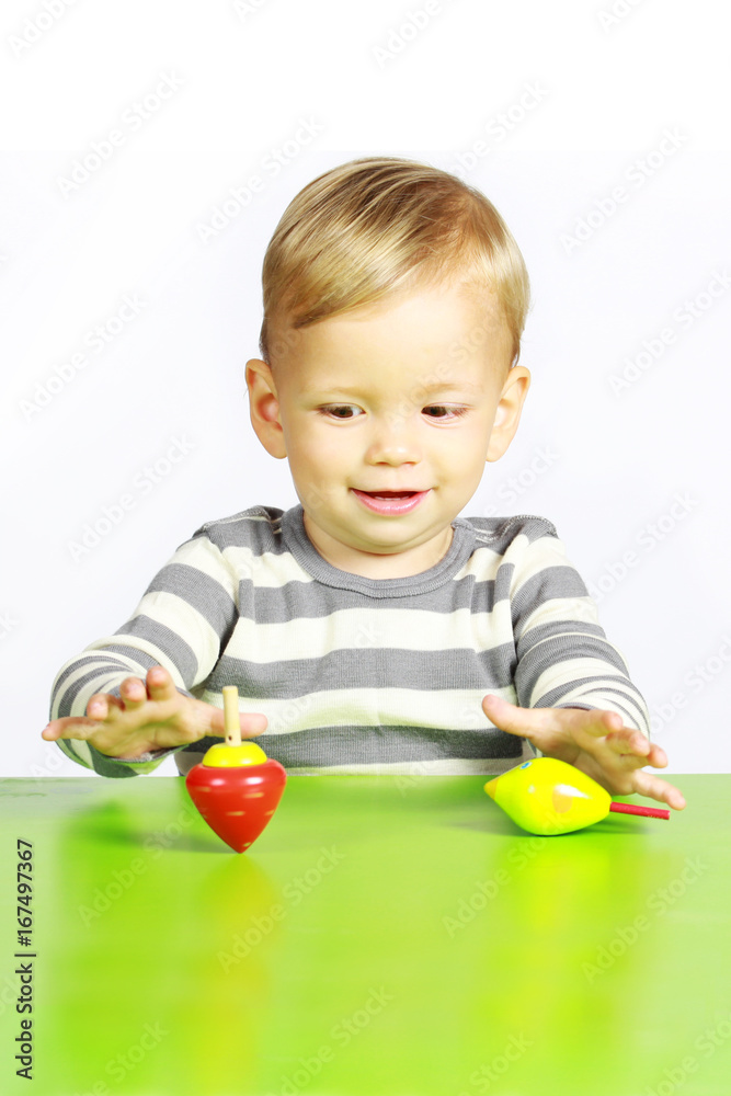 Ein einjähriger Junge spielt mit Holzspielzeug Ein einjähriger Junge spielt mit Holzspielzeug