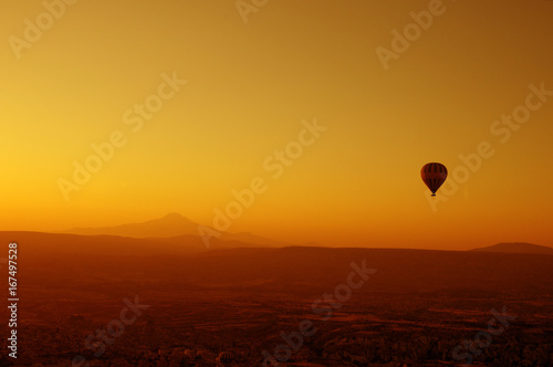 ballooning. A balloon flies in the sky in the rays of the rising sun. A bright sky, a haze, an extinct volcano on the horizon. © Евгений Кожевников