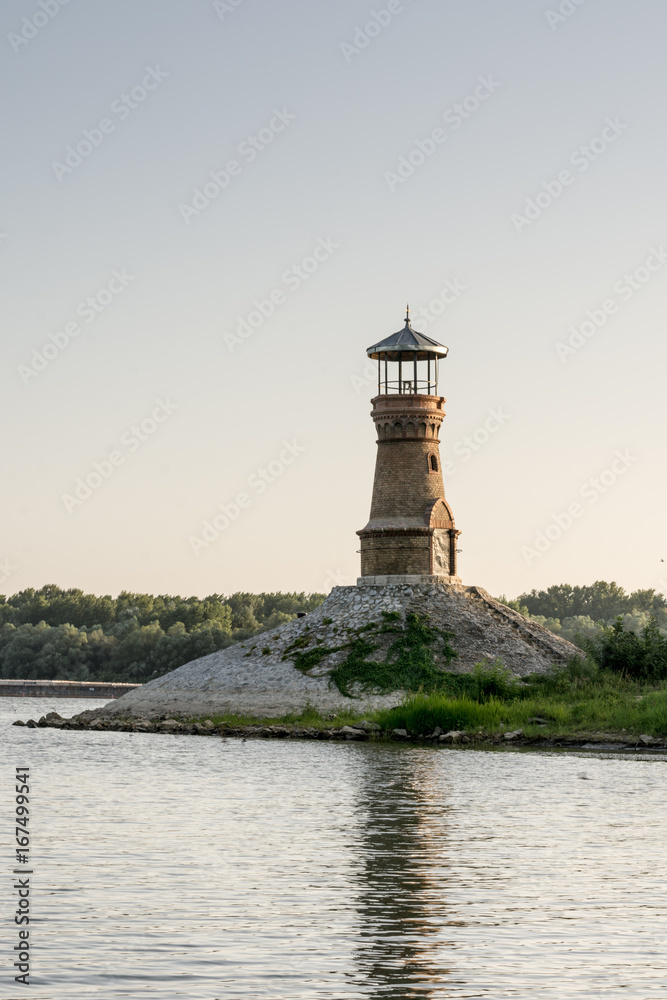 Old brick lighthouse on the river with clear sky