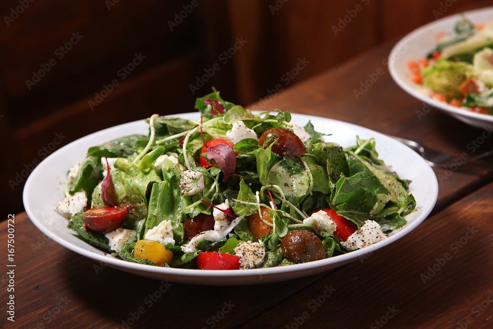 Healthy green salad with tomatoes and feta cheese Healthy green salad with tomatoes and feta cheese