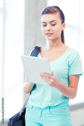 smiling student with tablet pc in college