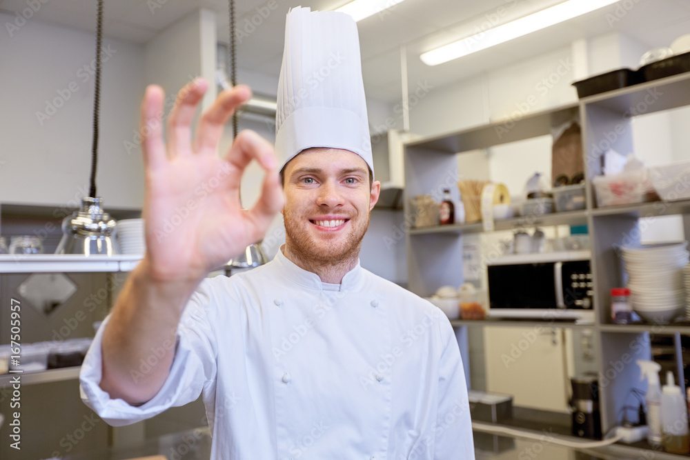 happy chef at restaurant kitchen showing ok sign