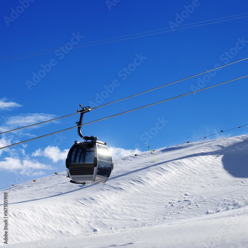 Gondola lift on ski resort at sun wind day