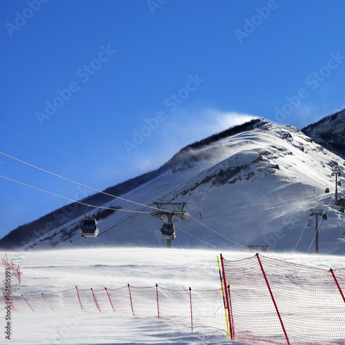 Gondola lift on ski resort at windy winter day photo