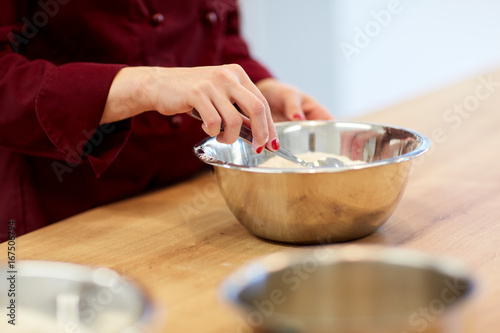 chef with flour in bowl making batter or dough