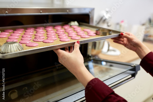 Schilderij op canvas chef with macarons on oven tray at confectionery