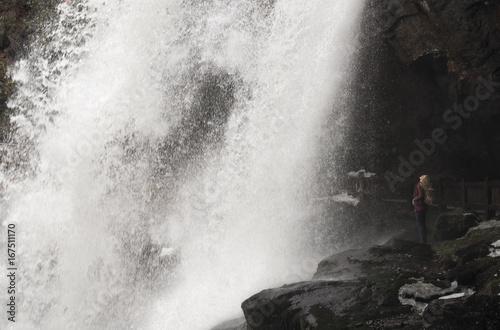 Side view of hiker standing on rocks against waterfall at Nantahala National Forest photo