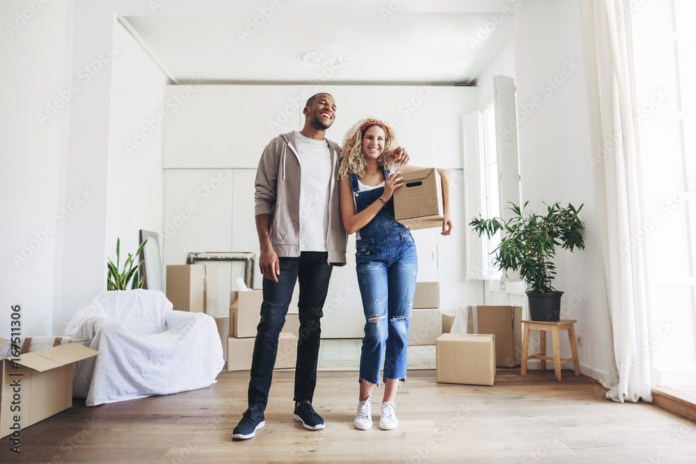 Cheerful couple standing at new home Cheerful couple standing at new home