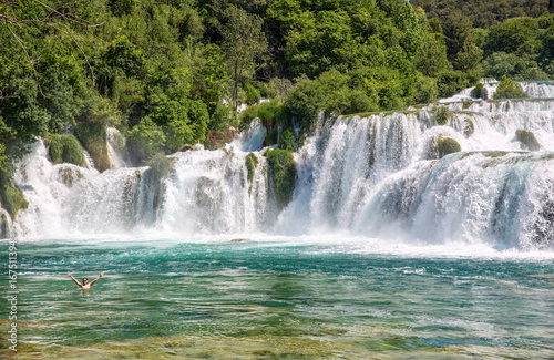 Wasserfall mit badender Person im Naturparadies Krka