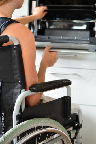Junge Frau im Rollstuhl führt ihren Haushalt