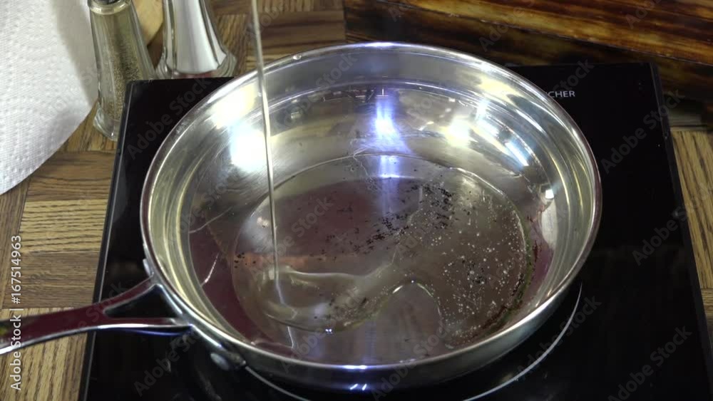 Slow motion pouring oil into a hot frying pan
Slow motion pouring oil into a hot frying pan
