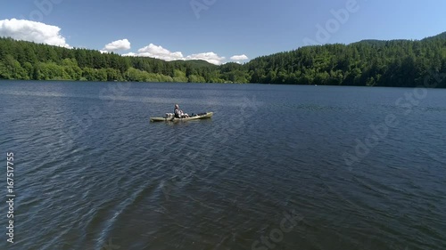 Slow Motion Fishing Aerial of Man Casting From Kayak on Lake photo