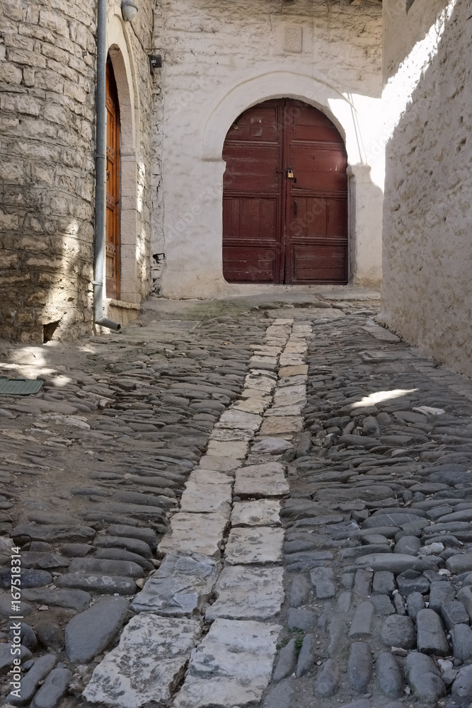 medieval street with wooden door in Berat city, Albania, vertical