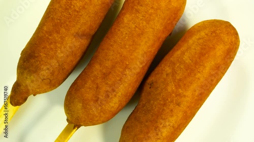 Top view of plate with three corn dogs spinning