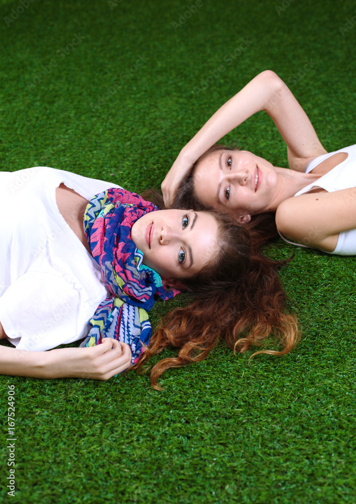 Two pretty girls lying on the fresh green grass Two pretty girls lying on the fresh green grass