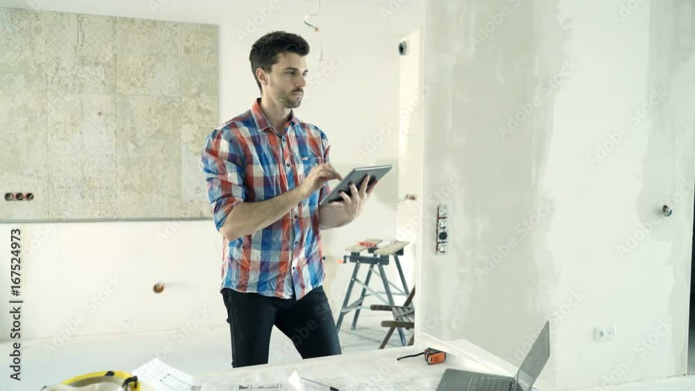 Young man with tablet computer checking his new home
Young man with tablet computer checking his new home