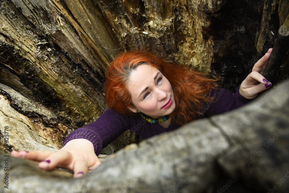 Redhead woman trapped in a tree