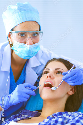 Woman dentist working at her patients teeth