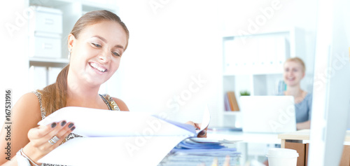 Fashion designers working in studio sitting on the desk