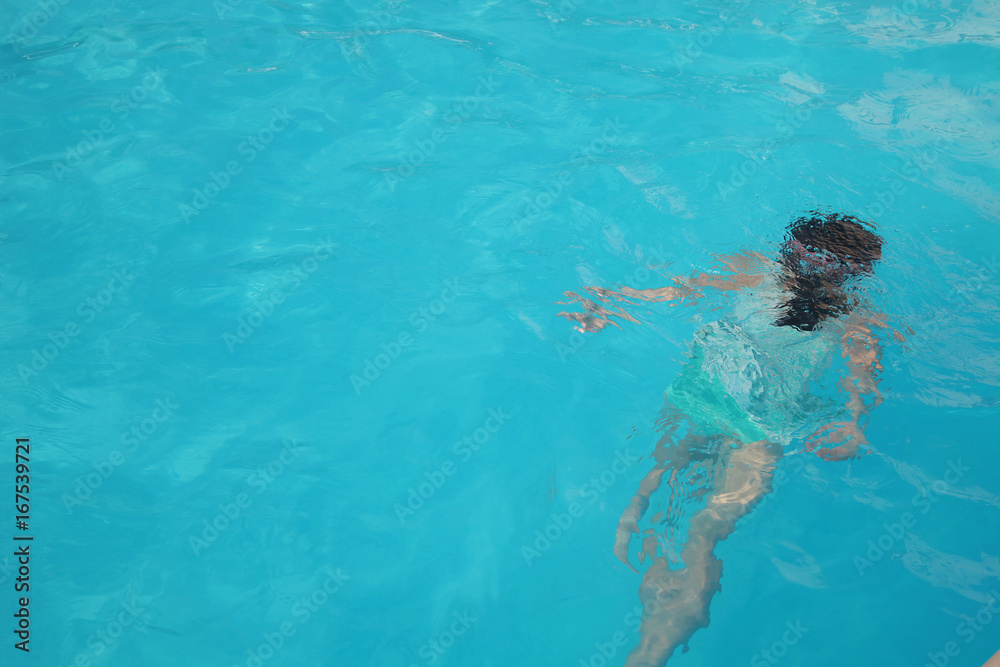 プールで泳ぐ少女